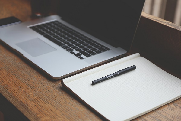 A laptop and notebook ready for creative thinking
